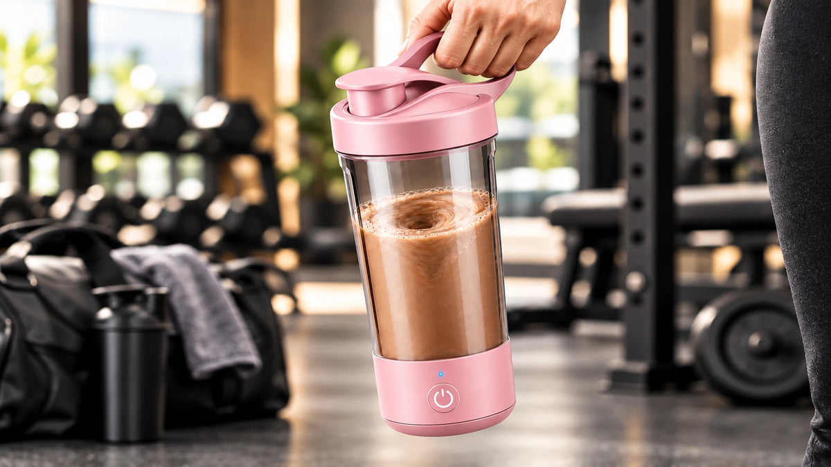 Vaso mezclador automático rosa con batido de proteína en el gimnasio